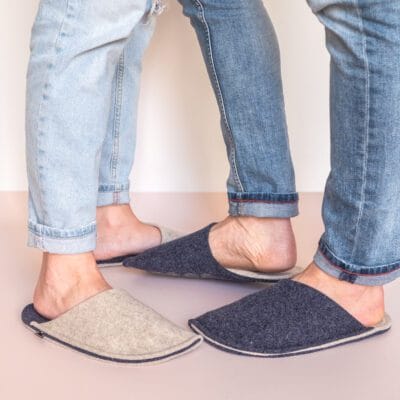 A couple wearing cream white and navy blue slippers
